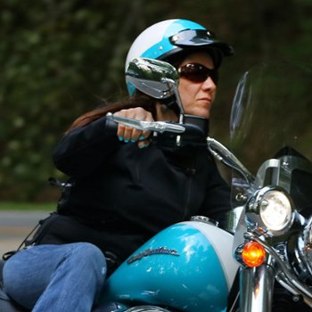 Woman riding motorcycle wearing Seer half shell motorcycle helmet